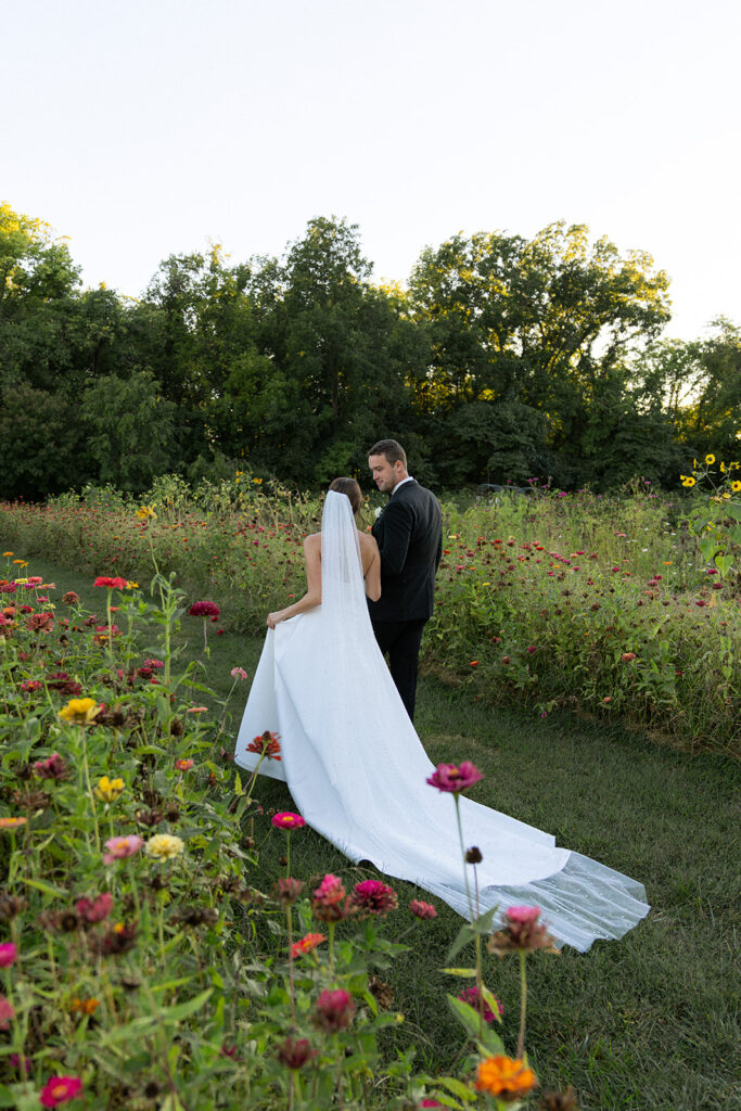 bride and groom holding hands walking around the vineyard 