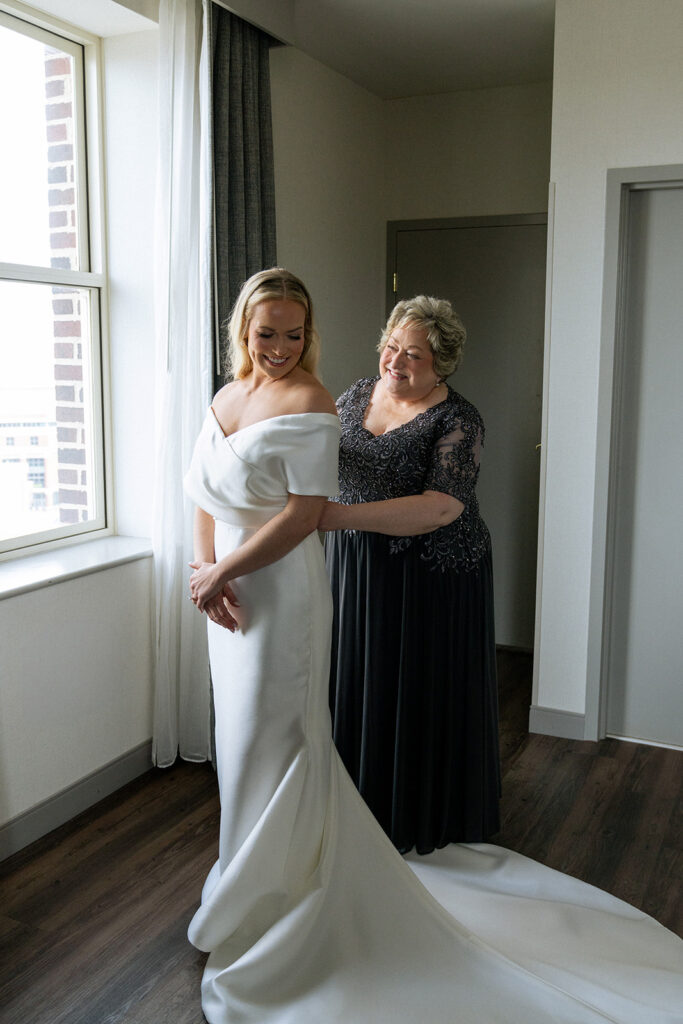 mother of the bride helping her get ready for the ceremony