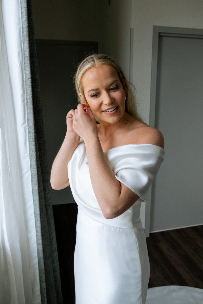 bride putting on her jewelry for the ceremony