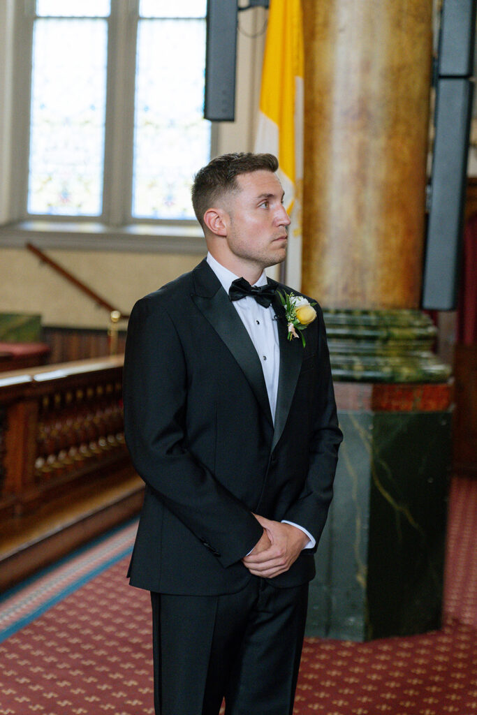 groom watching the bride walk down the aisle 