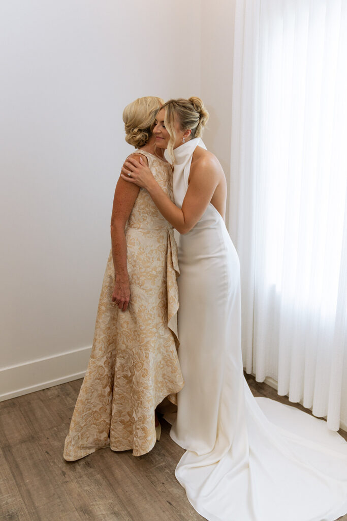 cute picture of the bride and her mom hugging 