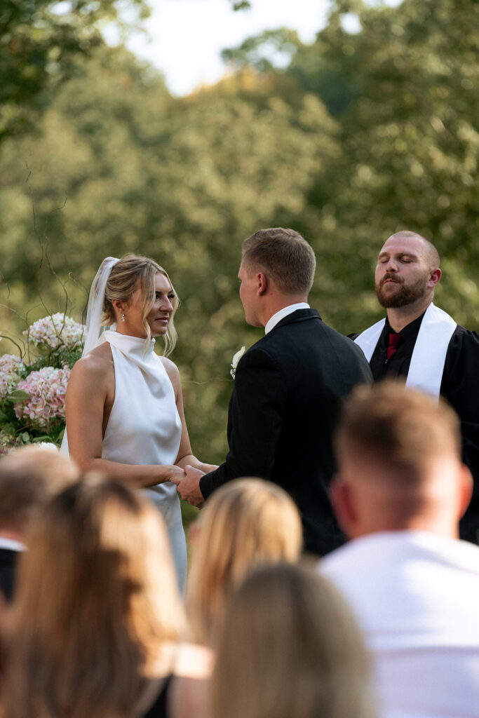 bride and groom holding hands at the wedding ceremony 