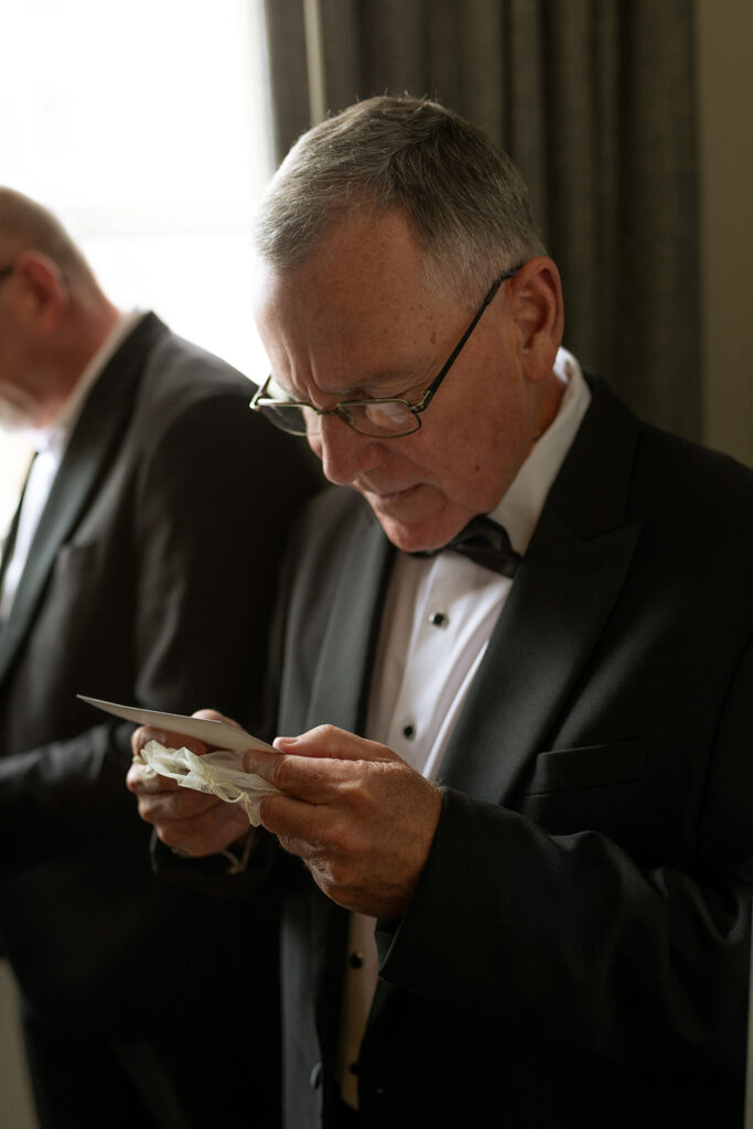 father of the groom reading a gift from the groom