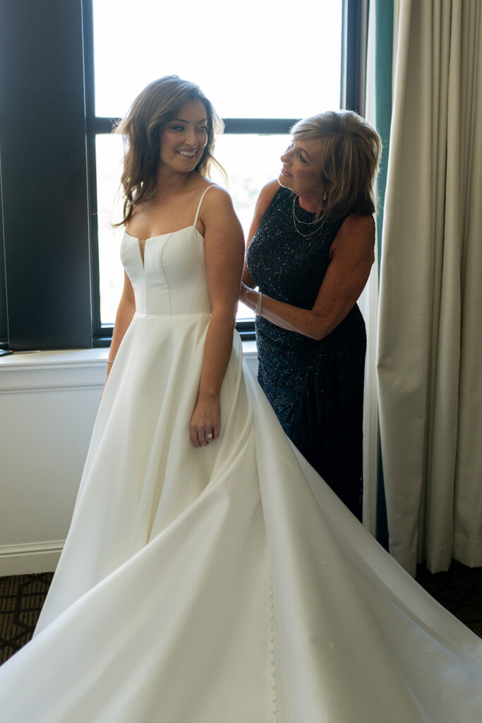 mother of the bride helping her get ready for the ceremony