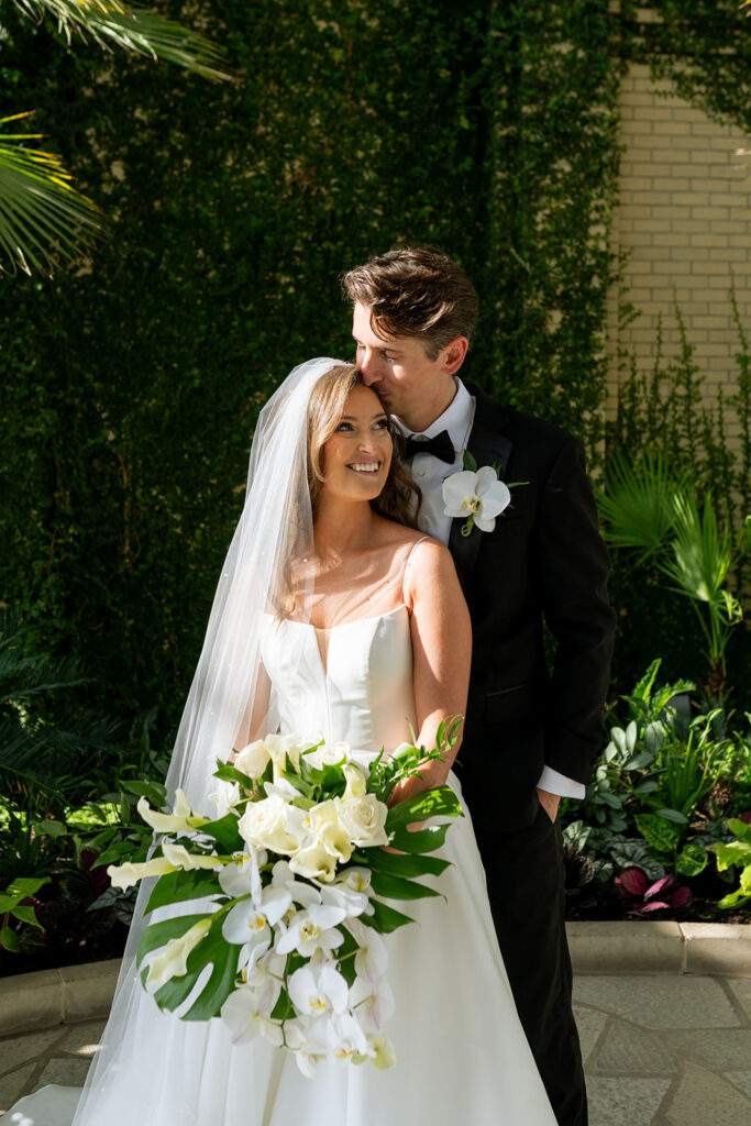 picture of the groom kissing the bride on the forehead 