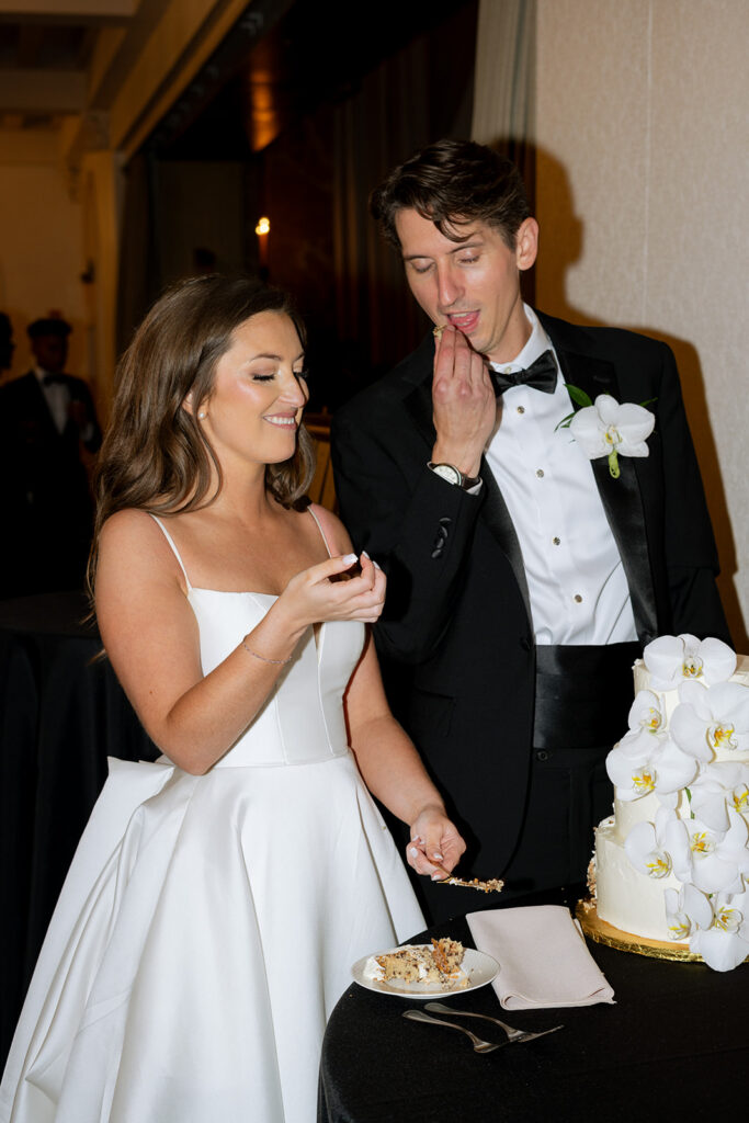 cute couple trying their wedding cake 