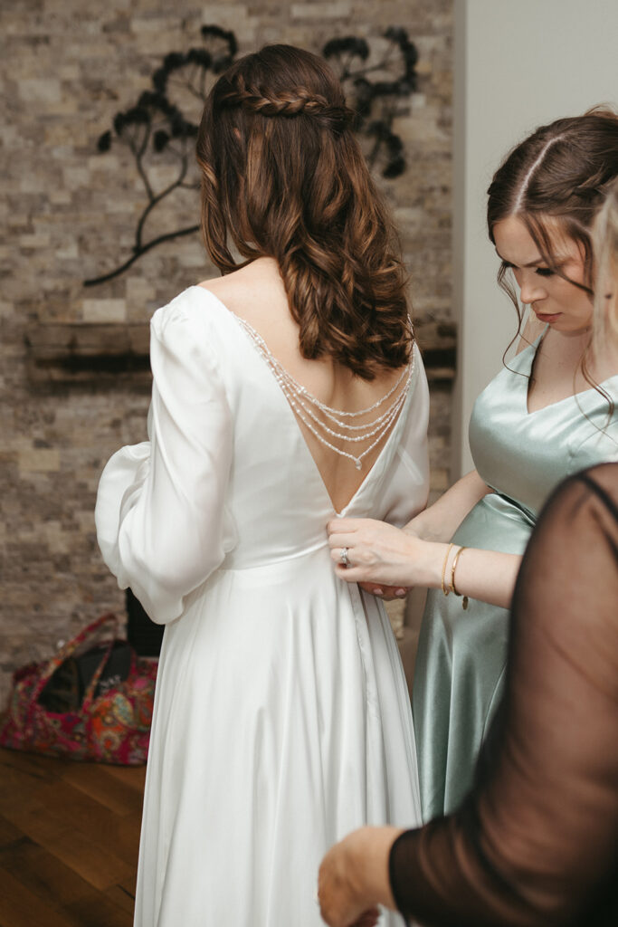 bridesmaids helping the bride get ready for her ceremony