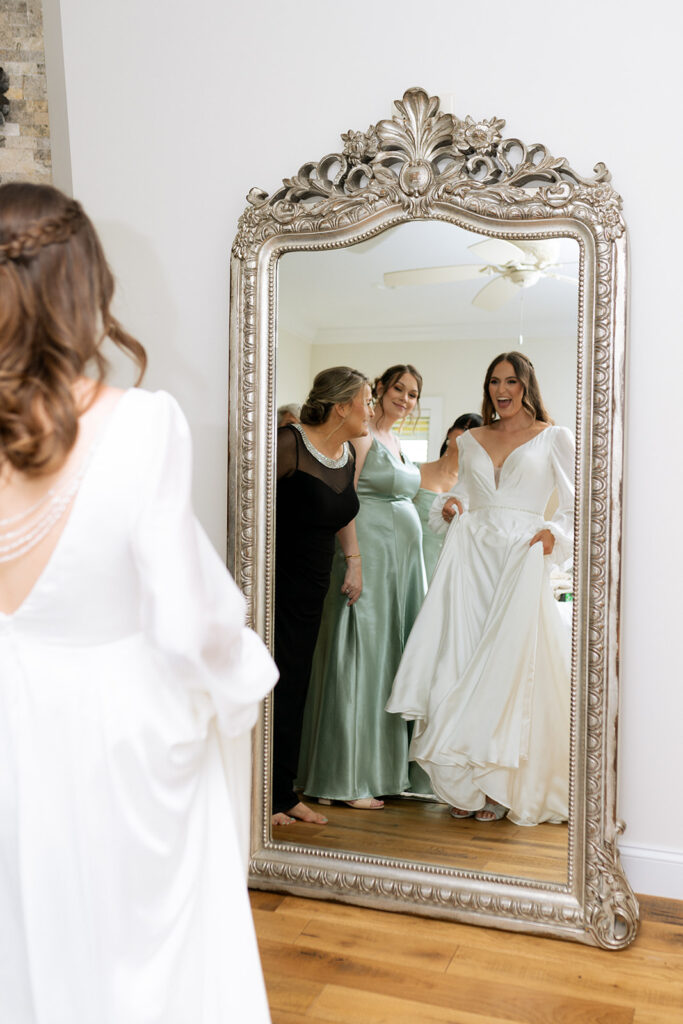 mother of the bride helping her with the wedding dress