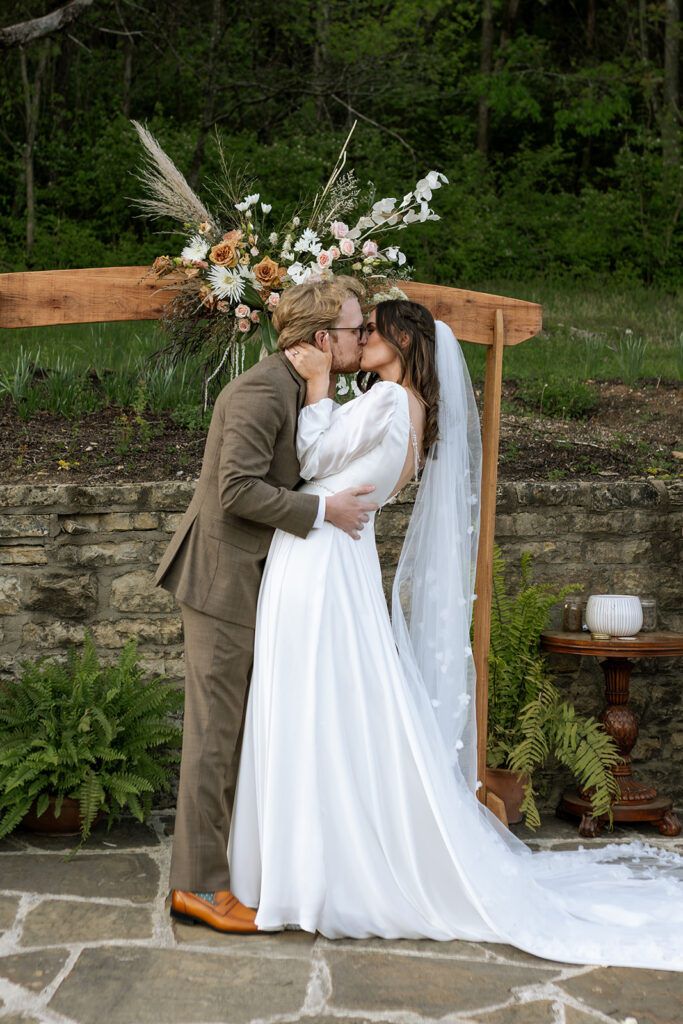 bride and groom kissing after their wedding ceremony