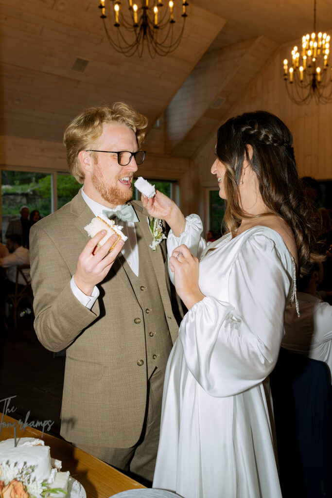 newlyweds trying their wedding cake 