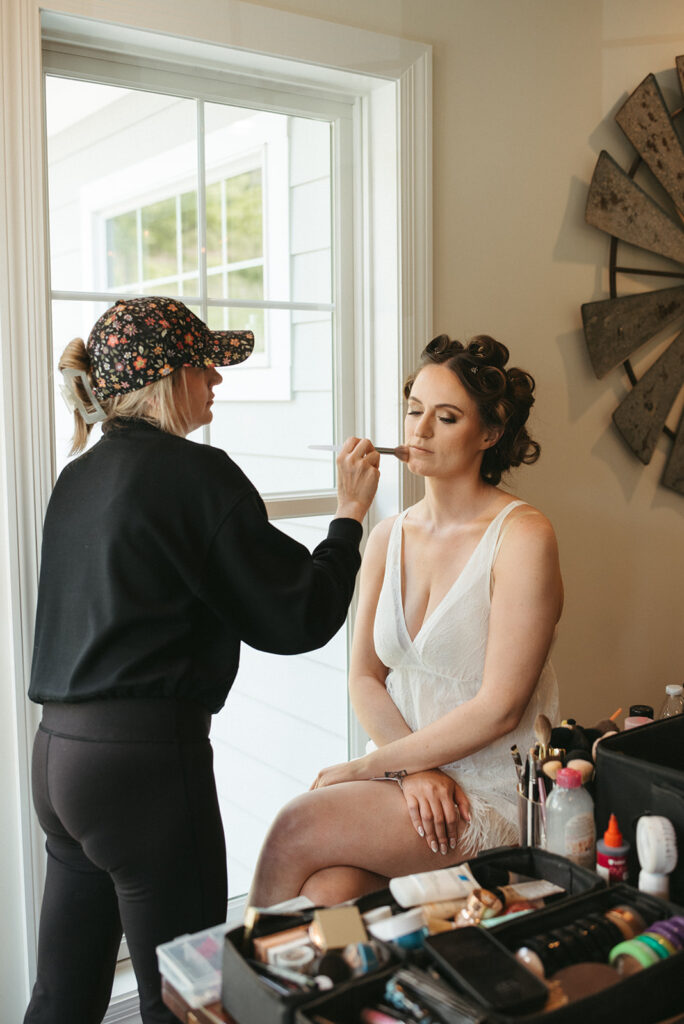 cute picture of the bride getting her makeup done for her ceremony
