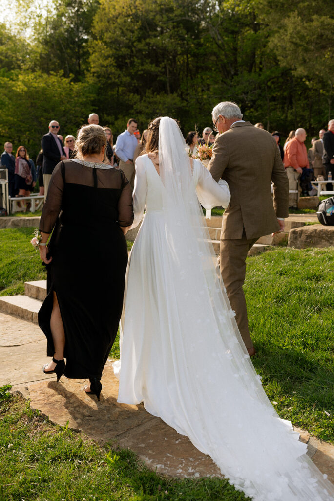 bride and her parents walking down the aisle 