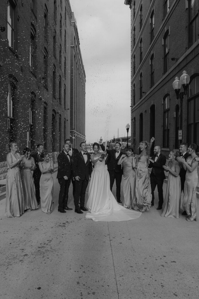 bride and groom with their bridesmaids and groomsmen celebrating with champagne
