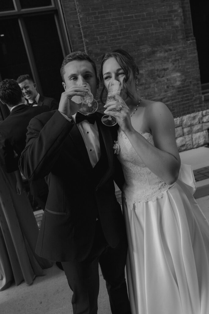 cute couple having a glass of champagne during their bridal portraits