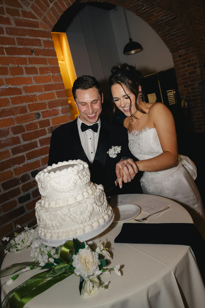 cute picture of the bride and groom cutting their wedding cake 