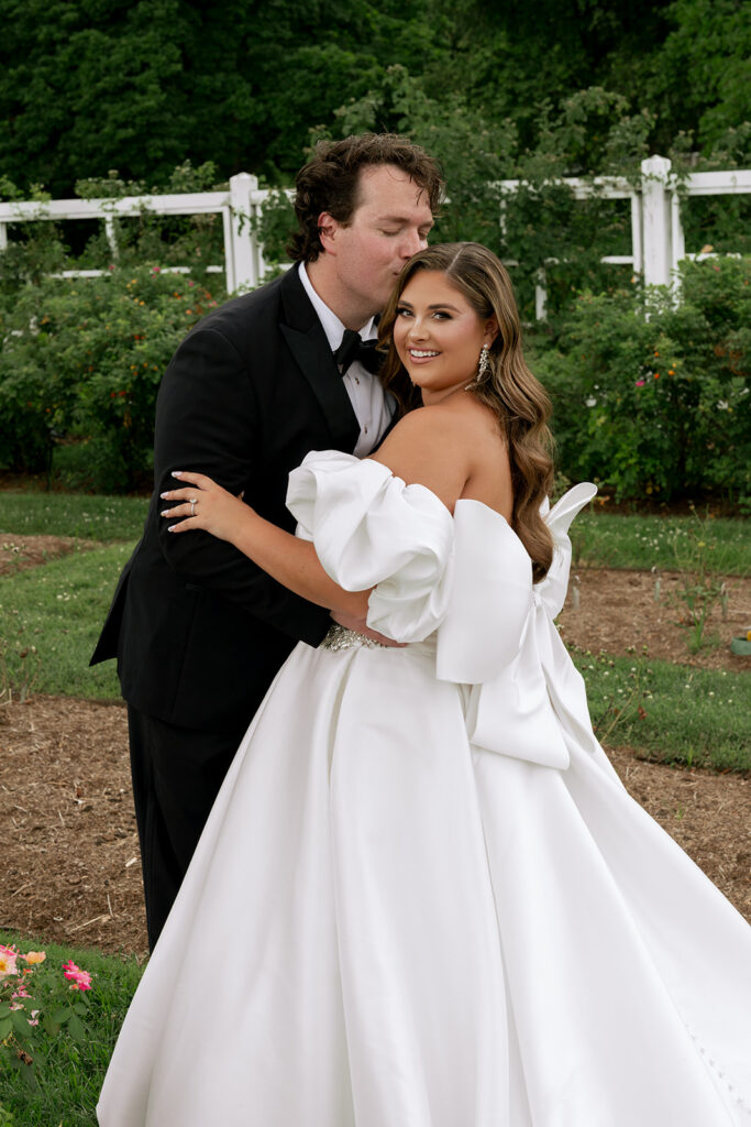 portrait of the groom kissing the bride on the forehead