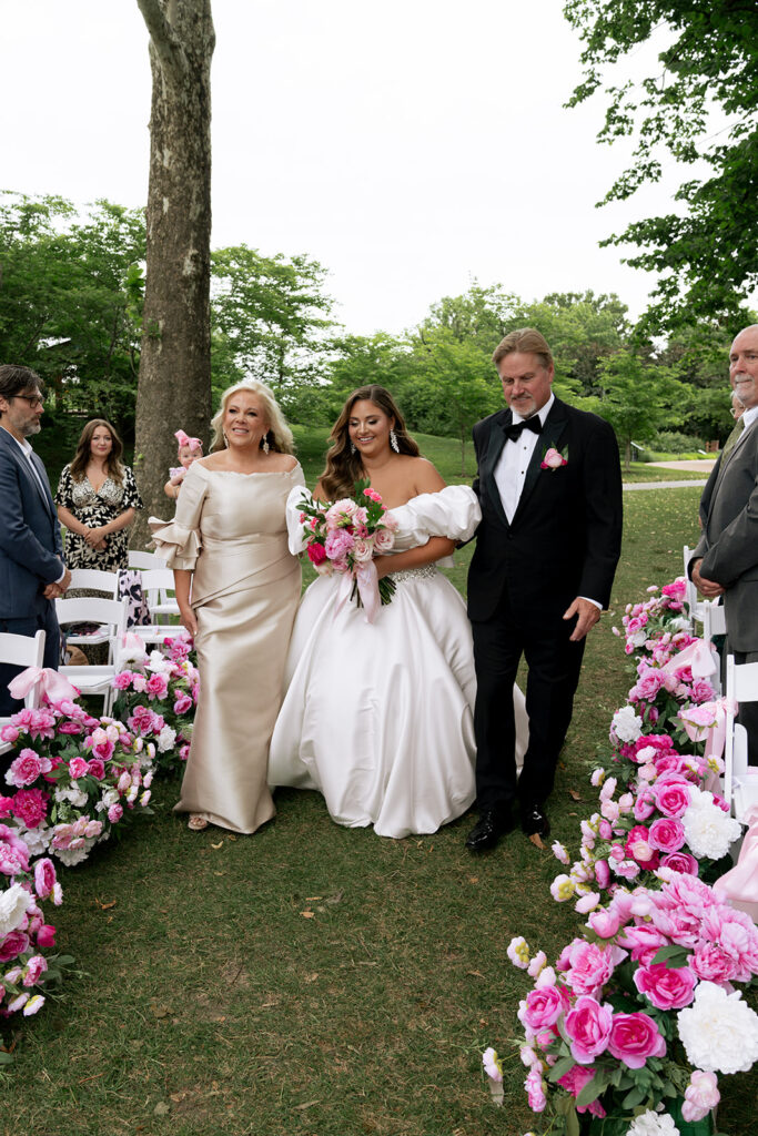 cute picture of the bride walking down the aisle with her mom and dad