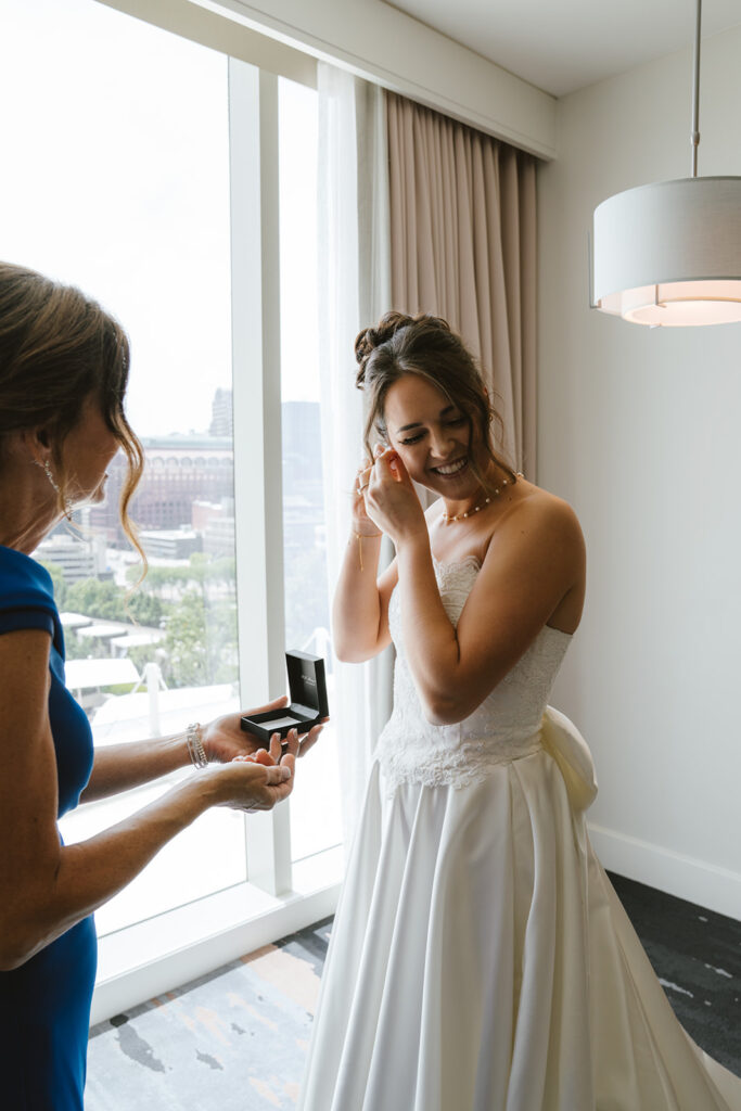 Bride putting on her jewelry before the ceremony