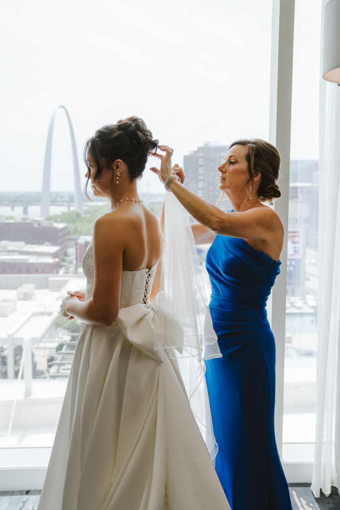 Mother of the bride helping her with the veil