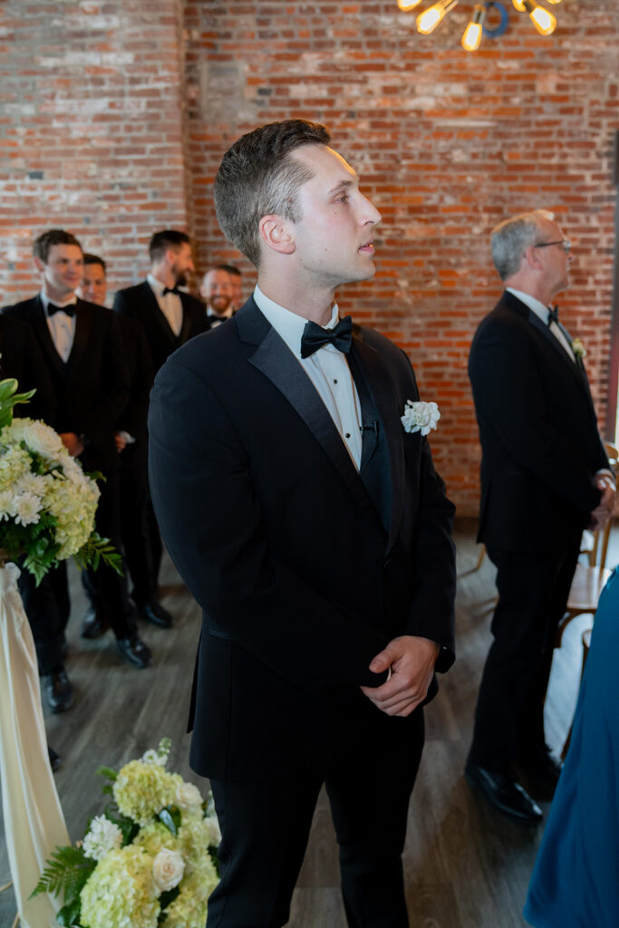 Cute picture of the groom, watching the bride walk down the aisle