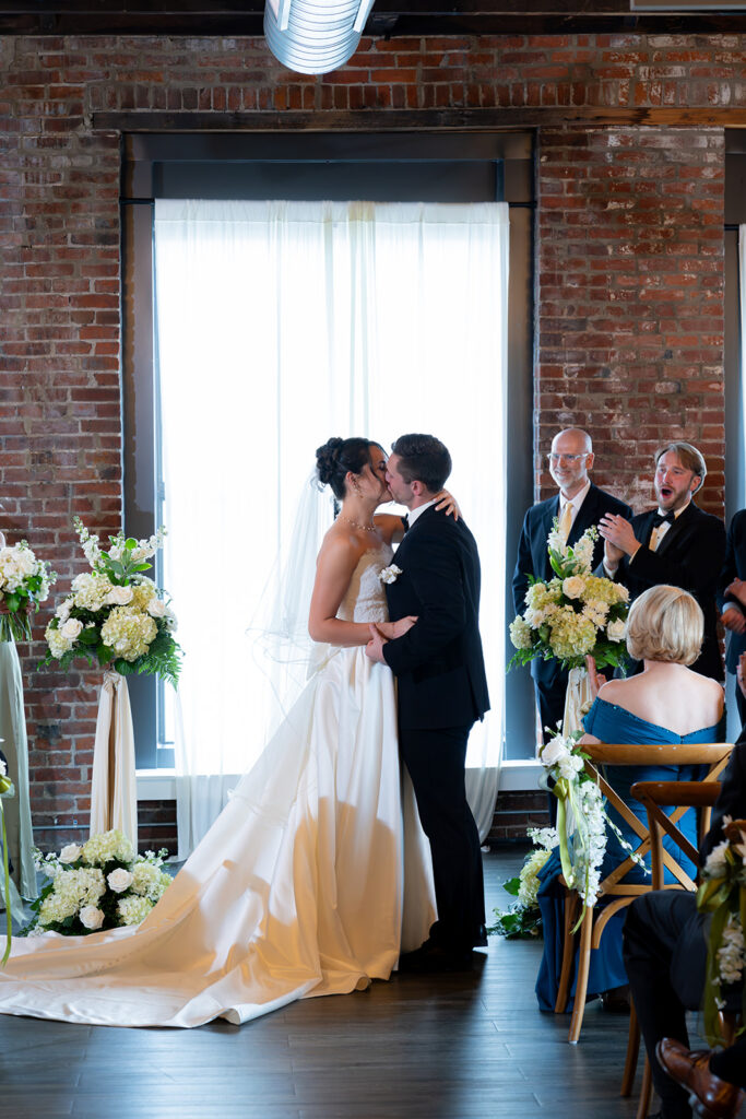 Bride and groom, kissing after their wedding ceremony