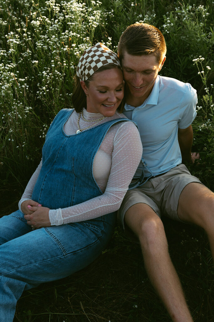 husband kissing his wife on the cheek during their session