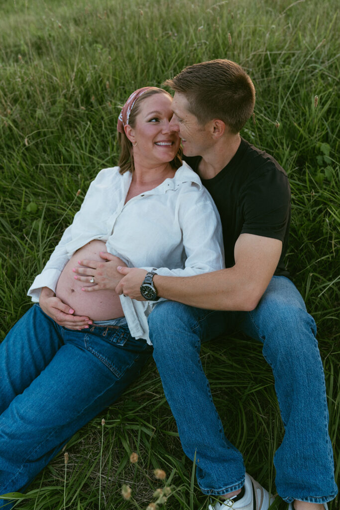 couple smiling at each other during their maternity photos