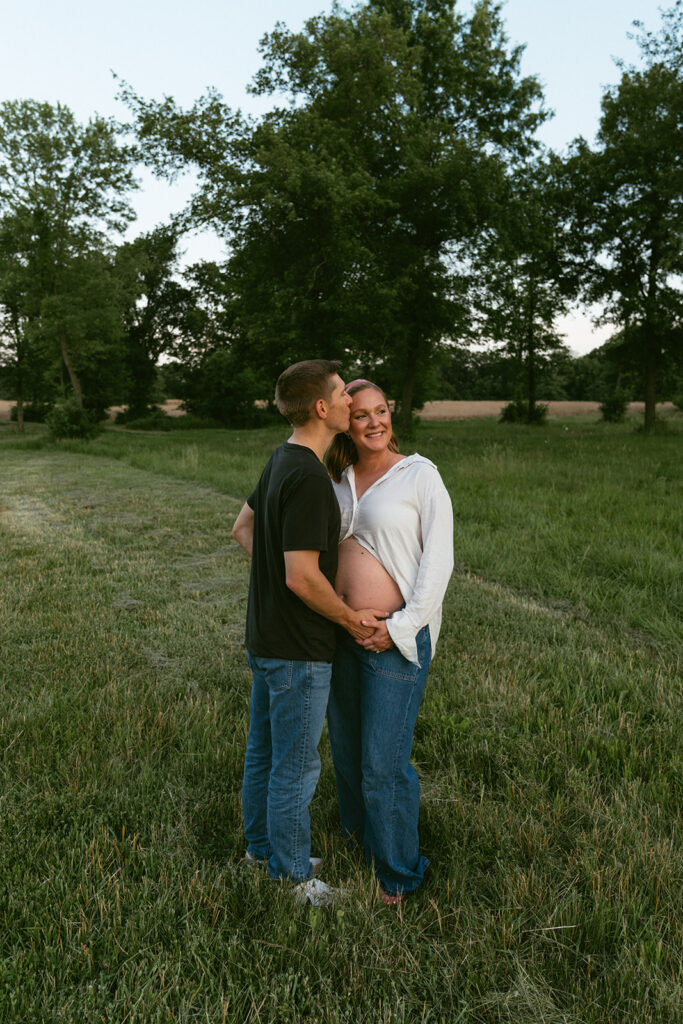 husband kissing his wife on the forehead during their photoshoot 
