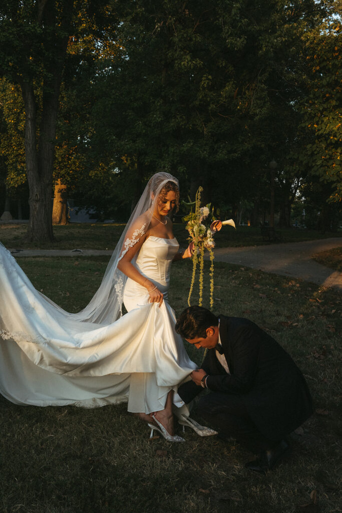 groom helping the bride with her wedding dress
