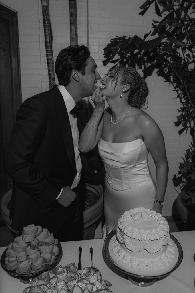 newlyweds trying their wedding cake