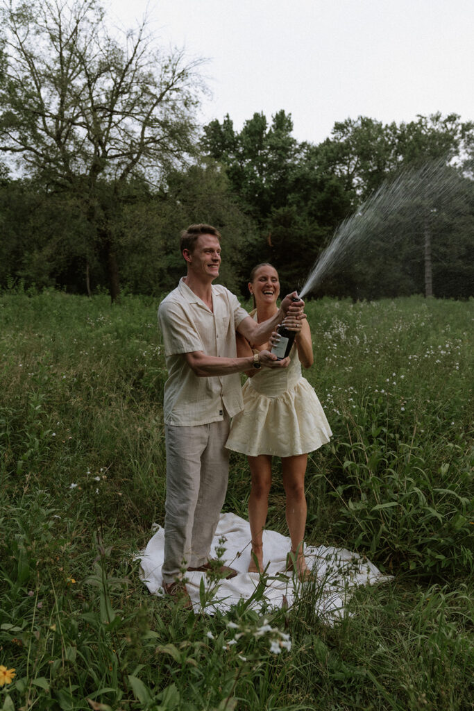 couple celebrating their engagement with champagne