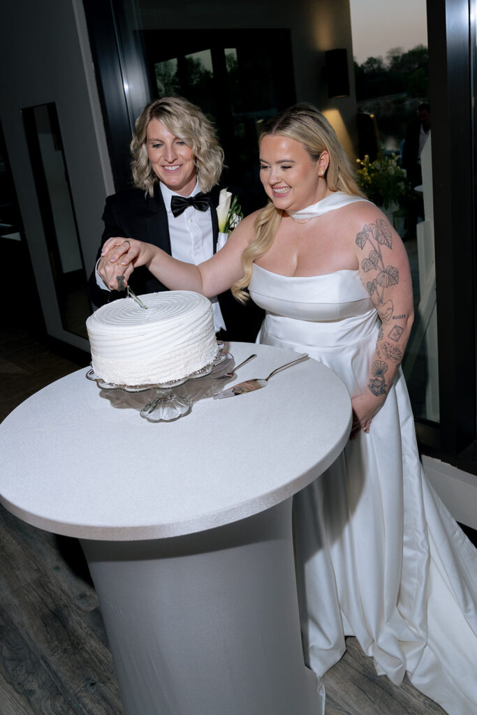 Newly married couple cutting their wedding cake