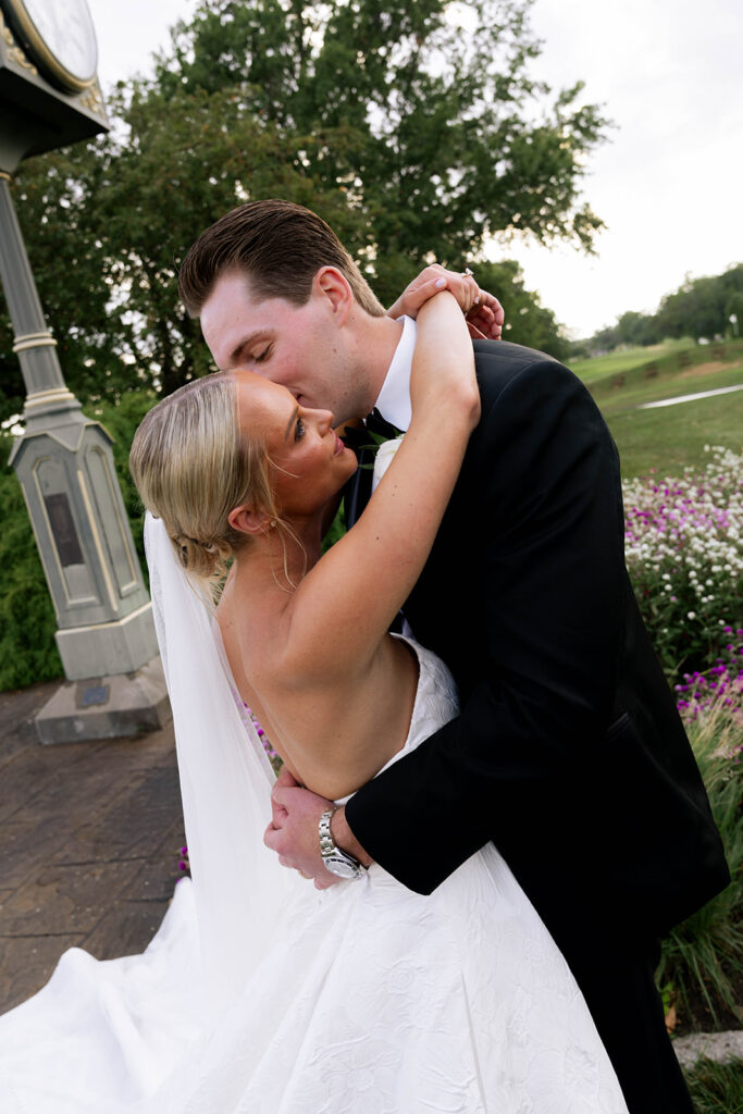 portrait of the groom kissing the bride on the cheek