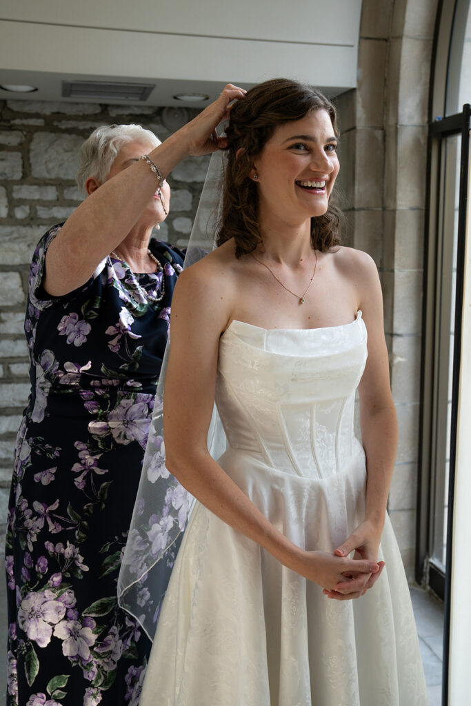 mother of the bride helping her with her wedding veil