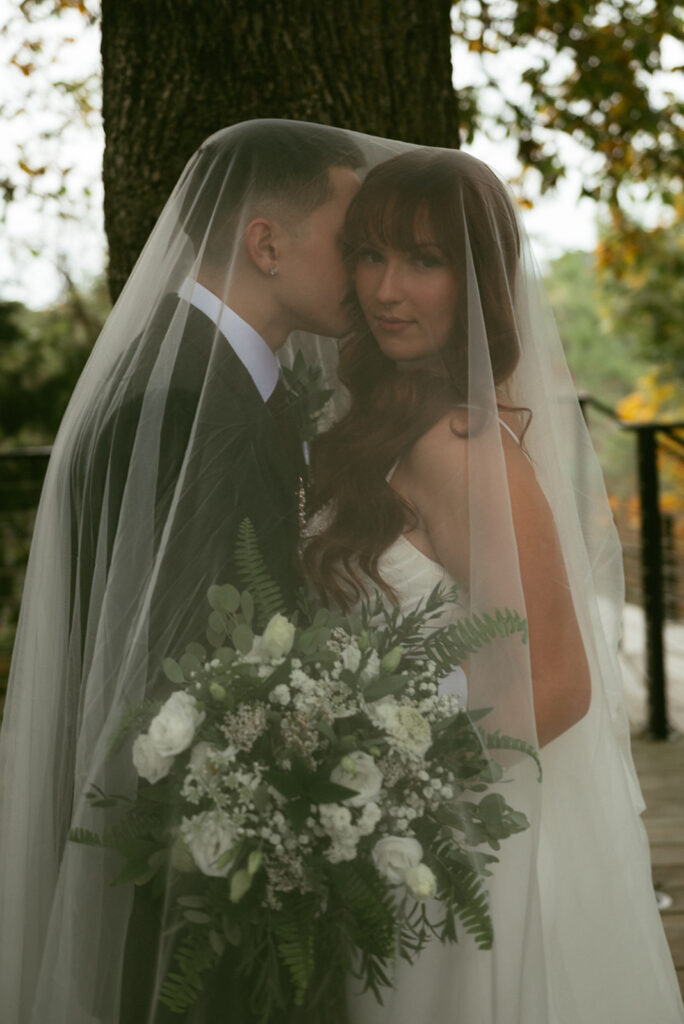 groom kissing the bride on the cheek