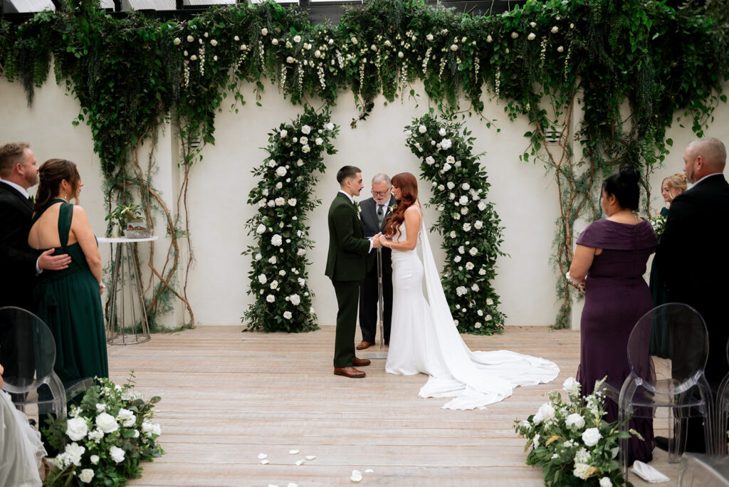 cute picture of the bride and groom holding hands during their ceremony