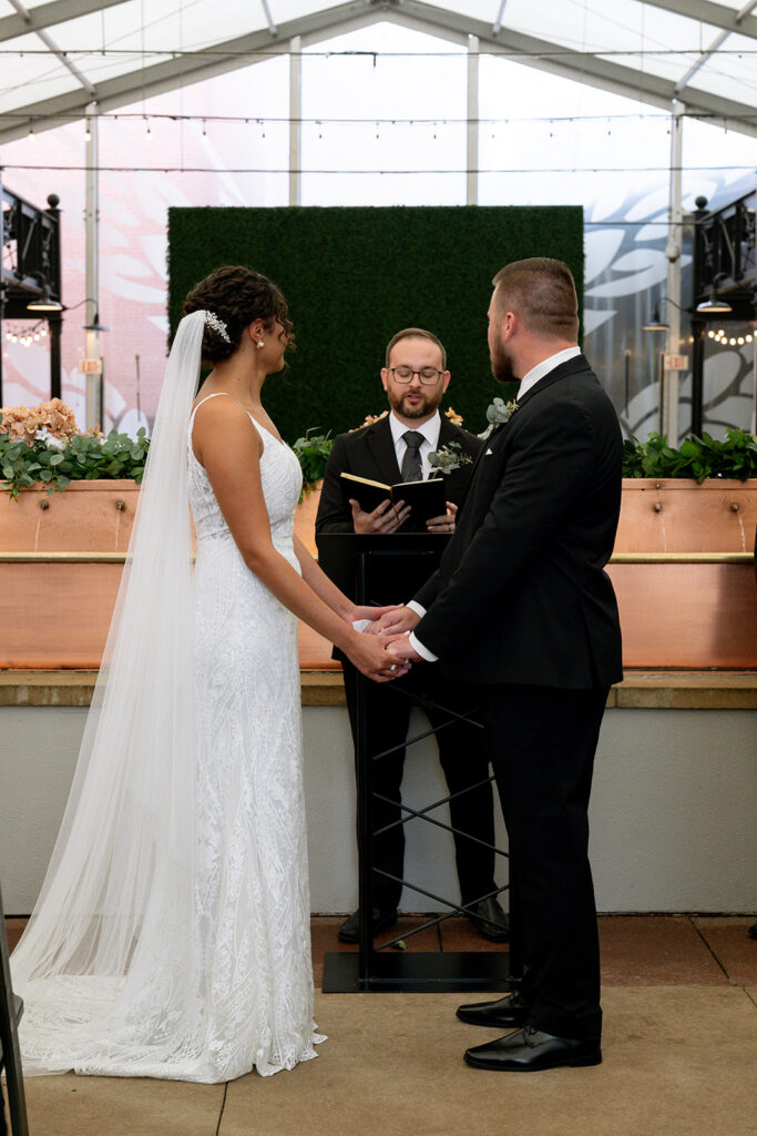 cute picture of the bride and groom holding hands during their ceremony