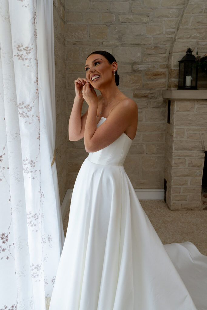 Bride putting on her jewelry before the ceremony