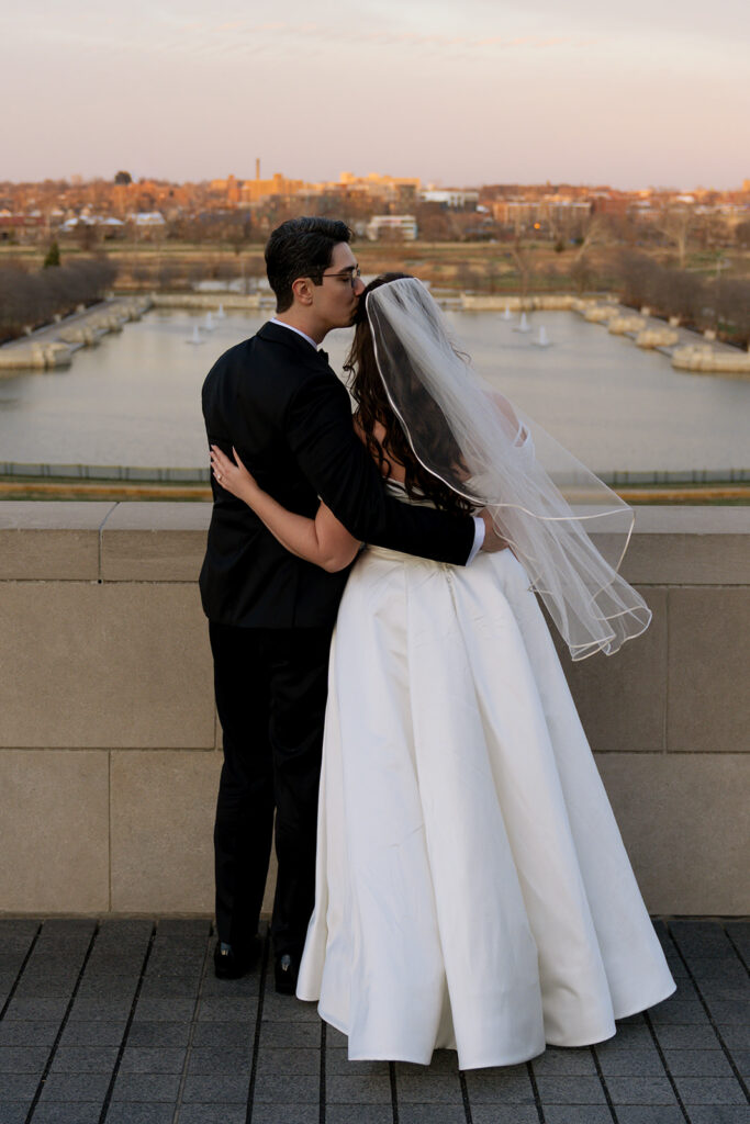 groom kissing the bride on the forehead