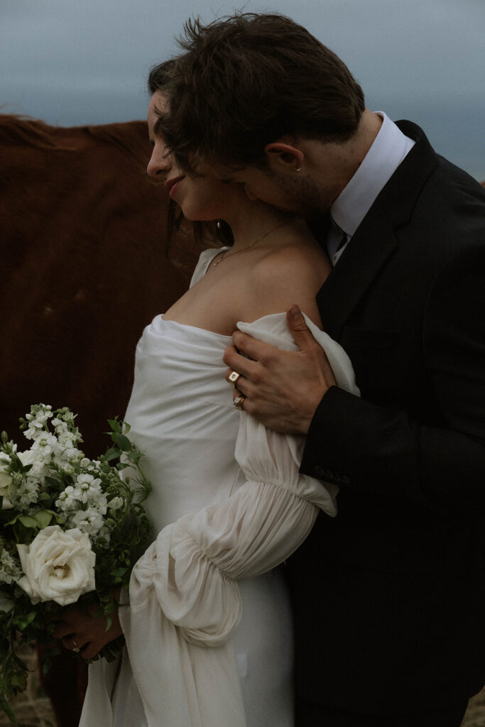 groom kissing the bride on the cheek