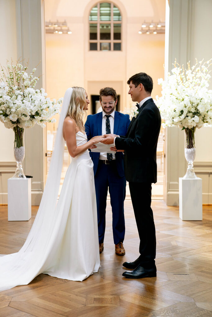 cute picture of the bride and groom holding hands during their wedding ceremony
