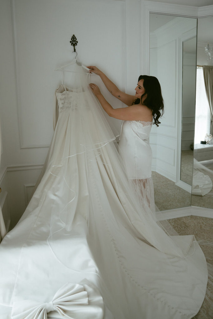 cute picture of the bride next to her wedding dress