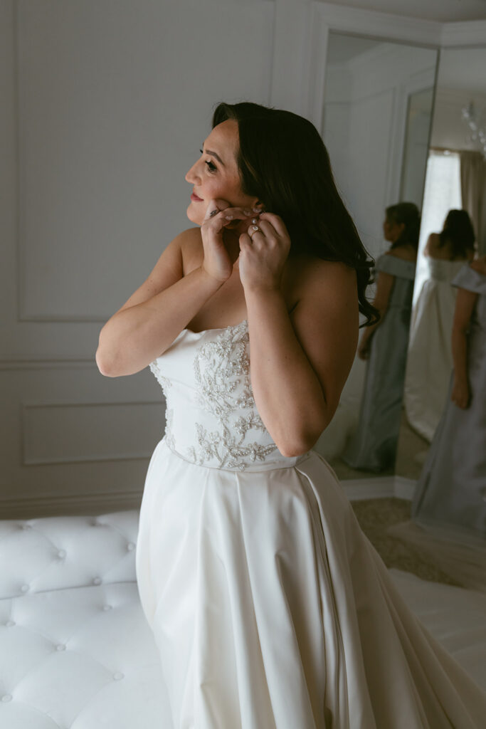 bride putting on her jewelry