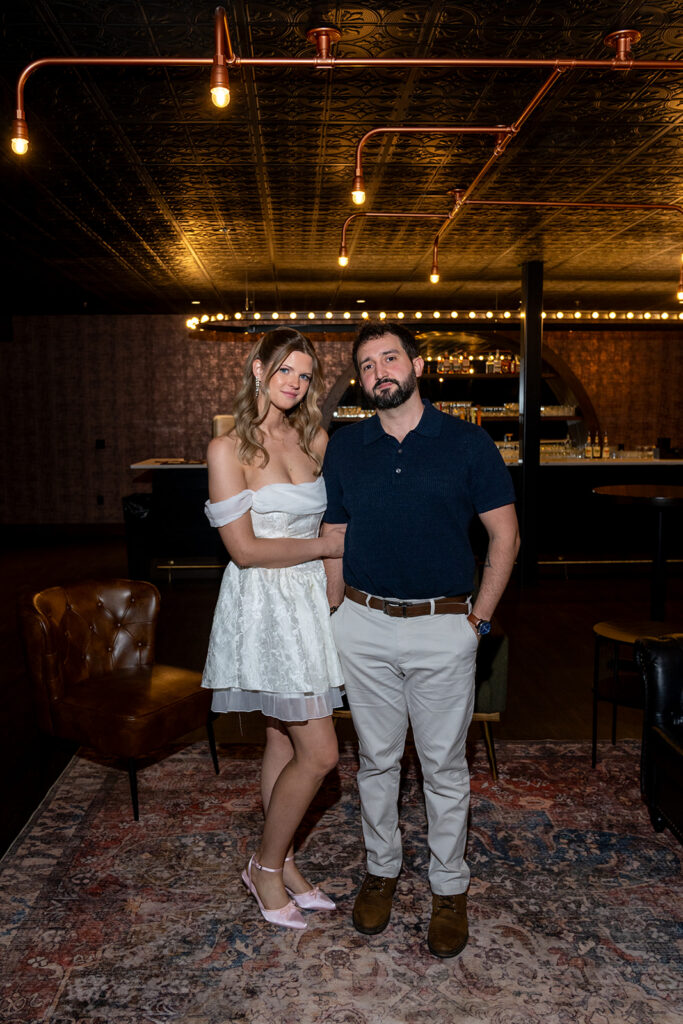 newly engaged couple smiling at the camera during their photoshoot