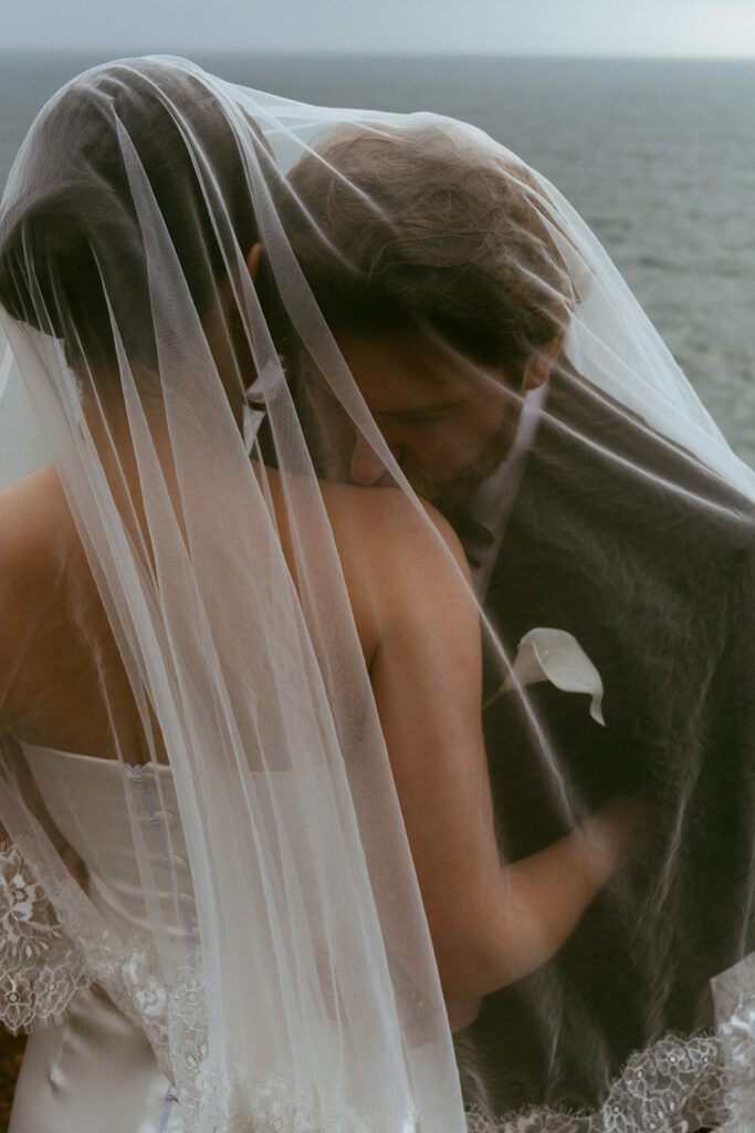 groom kissing the bride on the shoulder