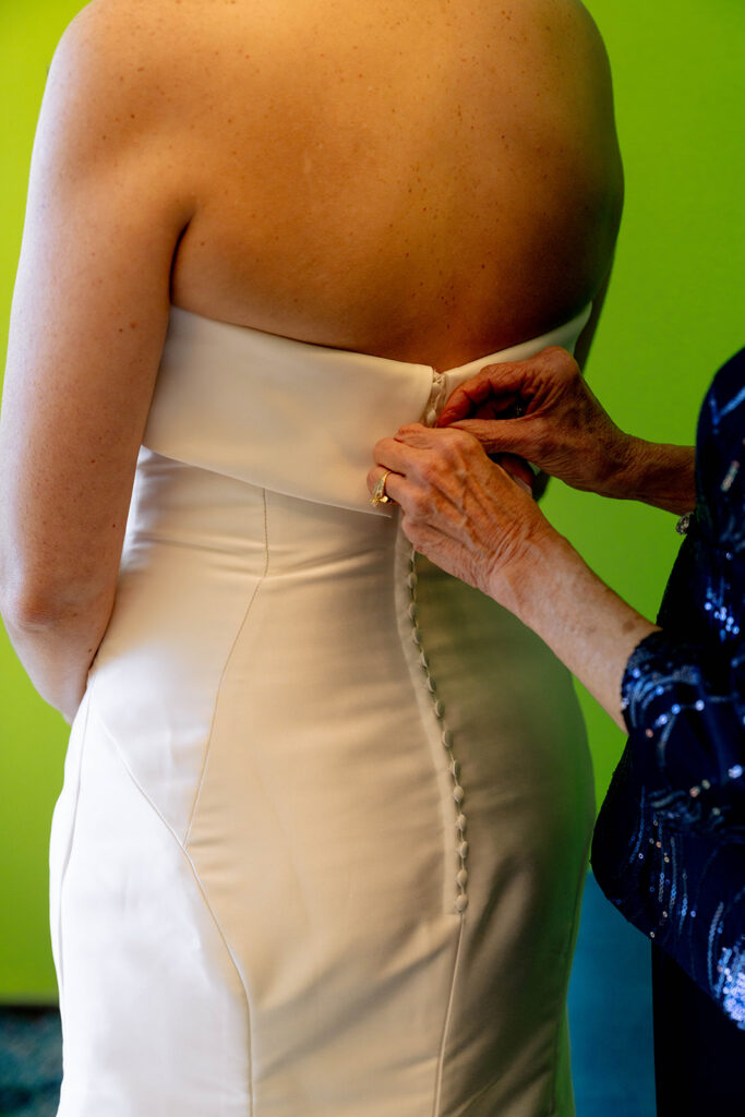mother of the bride helping her with her wedding dress