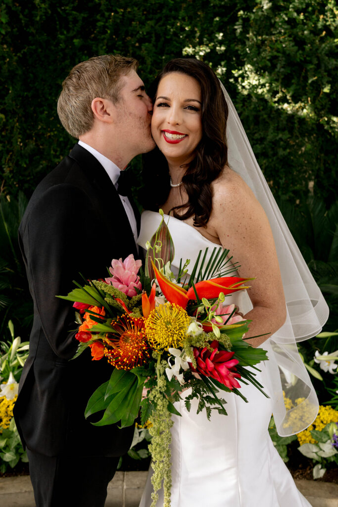 groom kissing the bride on the cheek